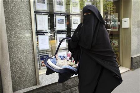 Anne, an assumed name, a 31-year old French woman who has been fined for wearing a niqab while driving, leaves after a news conference in Nantes